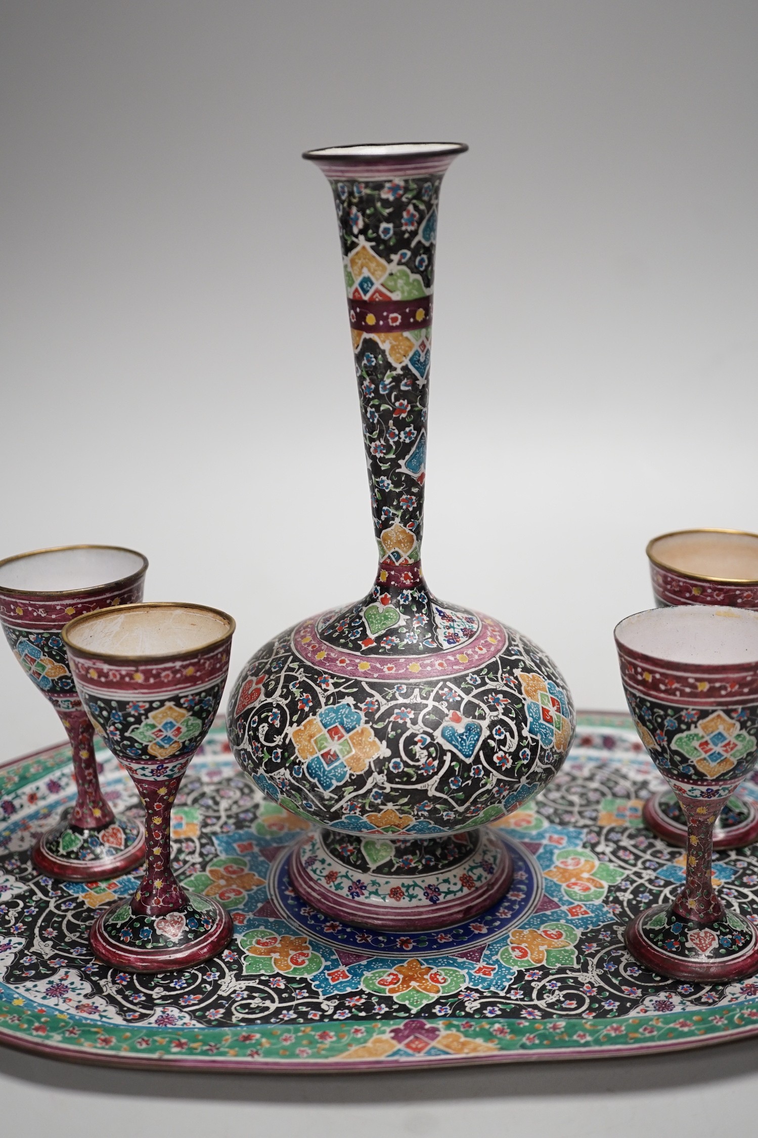 A decorative Persian enamel on copper set on stand. Tallest piece 20cm